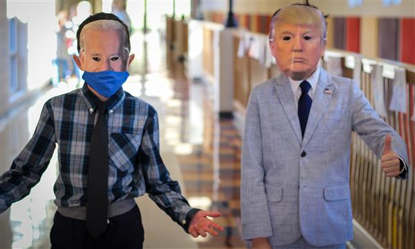Two students wear a Joe Biden and Donald Trump mask